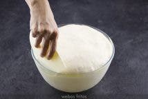 Pon un poco de harina en la encimera —no te pases de cantidad—. Con decisión y con la ayuda de tu rasqueta o de tus dedos separa la masa del cuenco